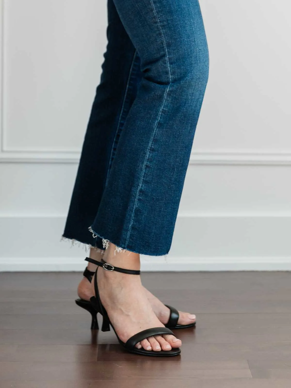 Cropped view of woman's legs wearing  kitten heel sandals with kick flares