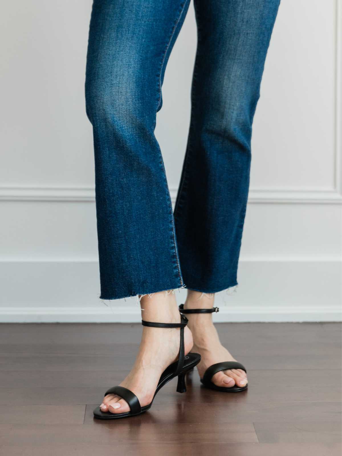 Cropped view of woman's legs wearing kitten heel sandals with kick flares