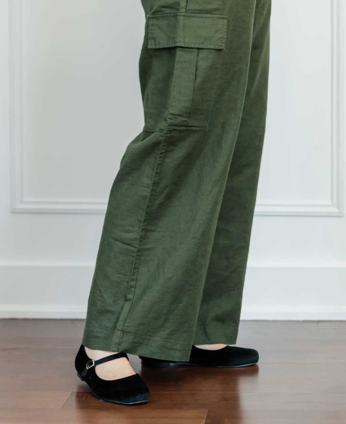 Cropped view of woman's legs wearing Mary Jane Ballet flats with full length wide olive green linen pants.