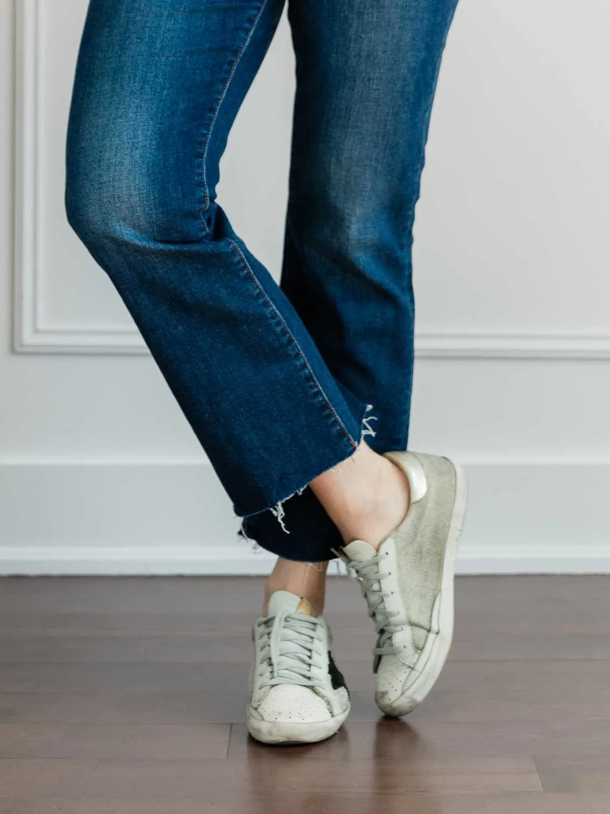 Cropped view of woman's legs wearing   sleek sneakers with kick flares