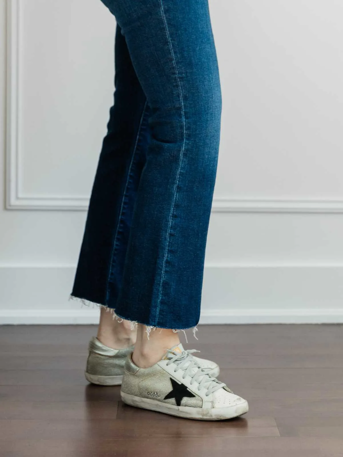 Cropped view of woman's legs wearing   sleek sneakers with kick flares