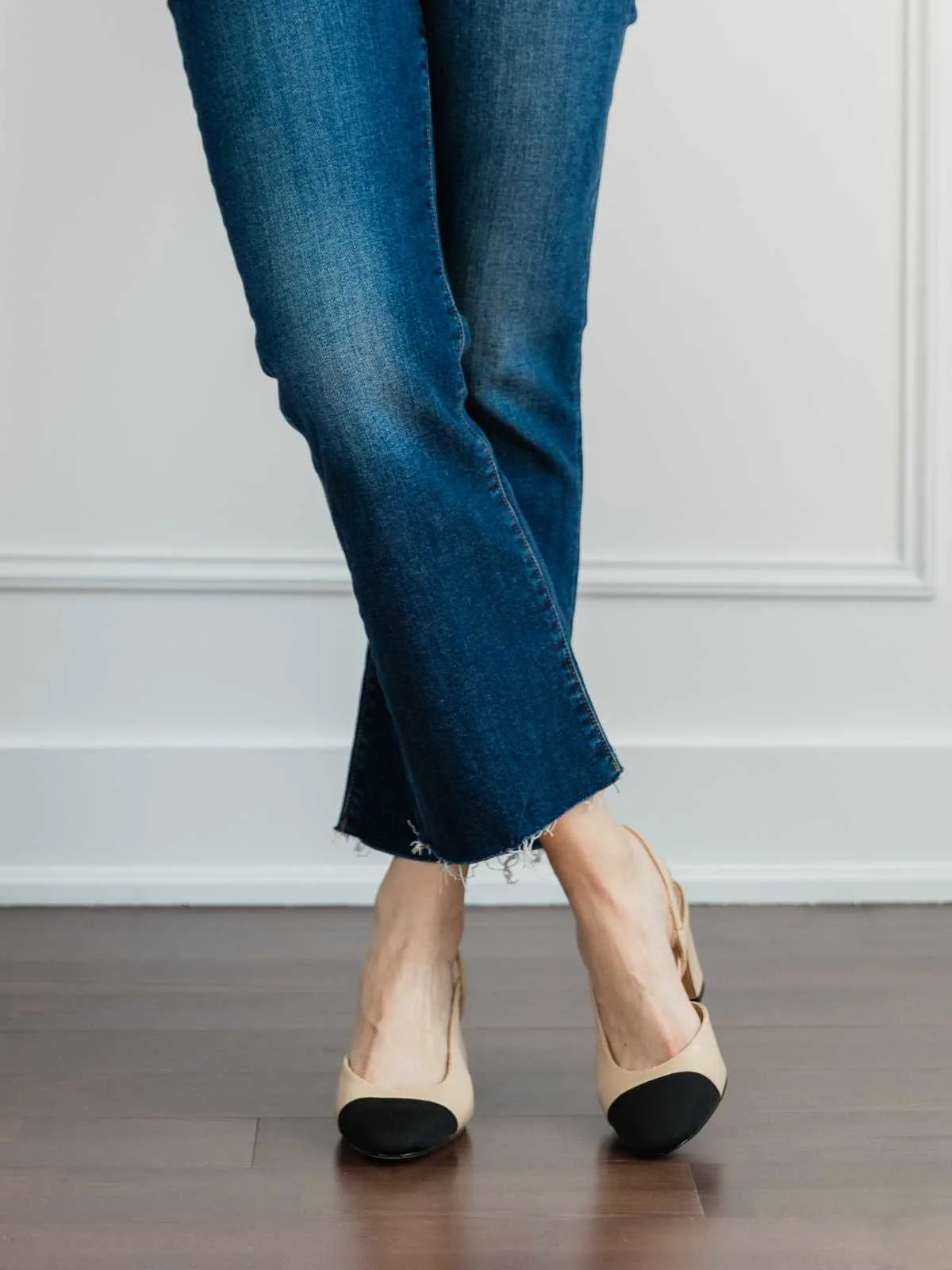Cropped view of woman's legs wearing slingback pumps with kick flares