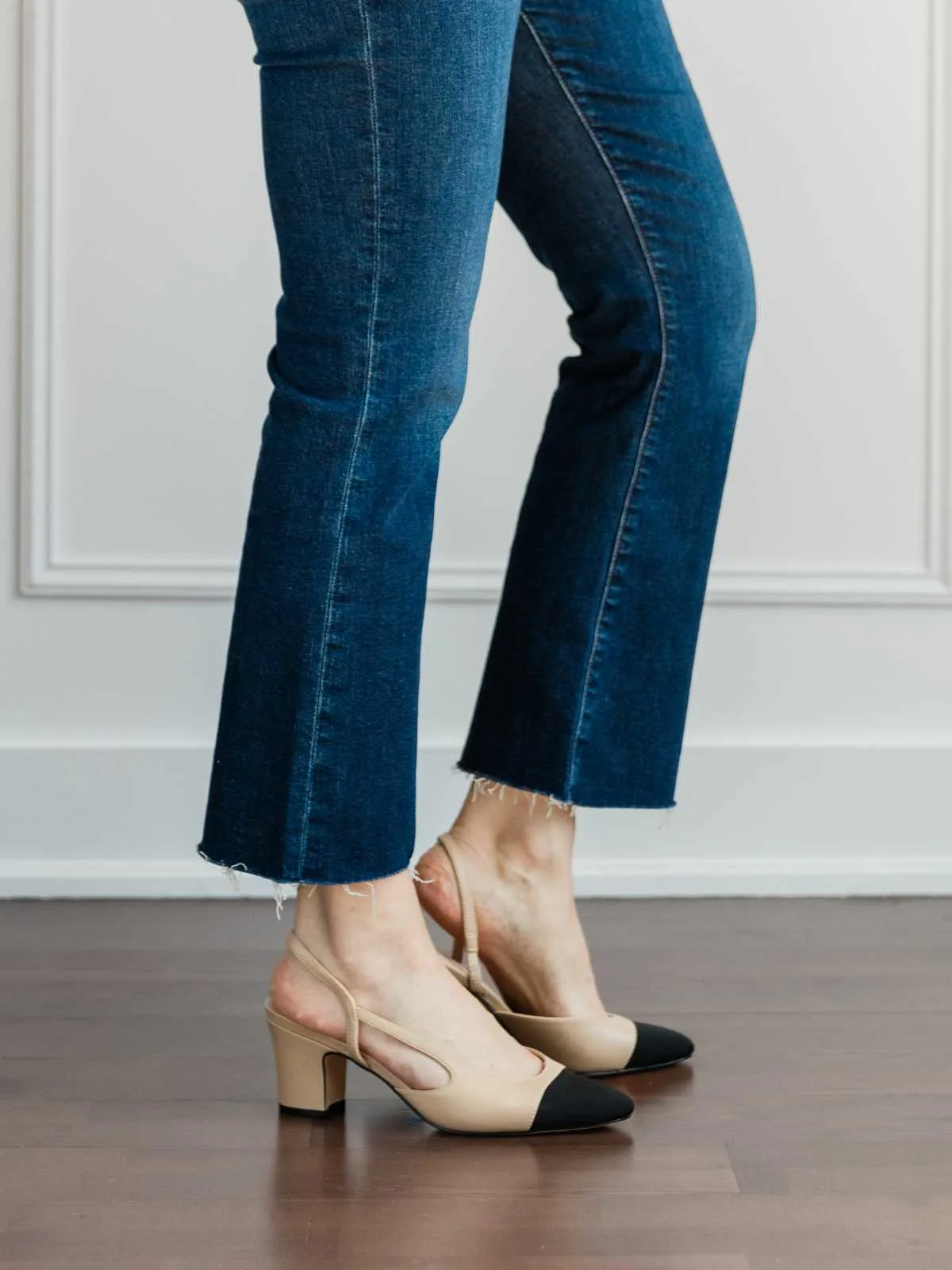 Cropped view of woman's legs wearing   slingback pumps with kick flares