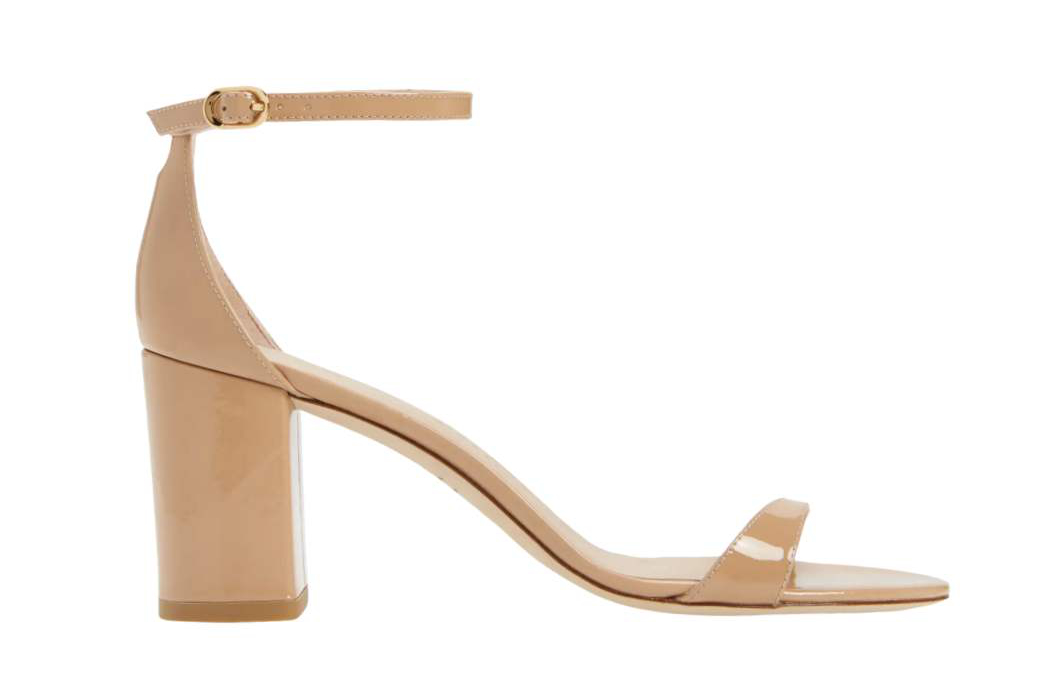 Minimal heeled sandals in patent beige color on white background.